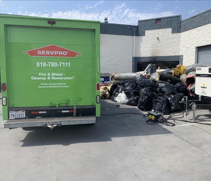 Truck loading garbage bags of damaged materials