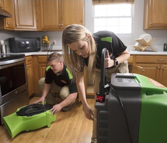 a SERVPRO crew setting up machines to clean a kitchen