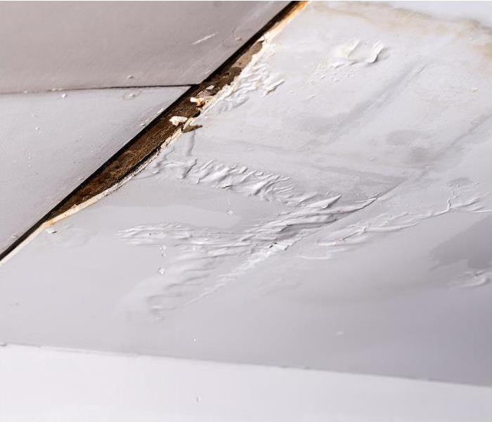 a white ceiling showing signs of water damage from a leak