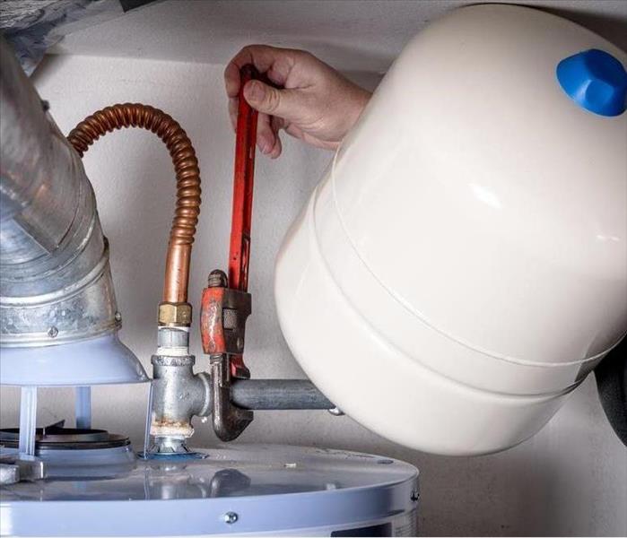 Plumber installs a compression tank on a hot water heater