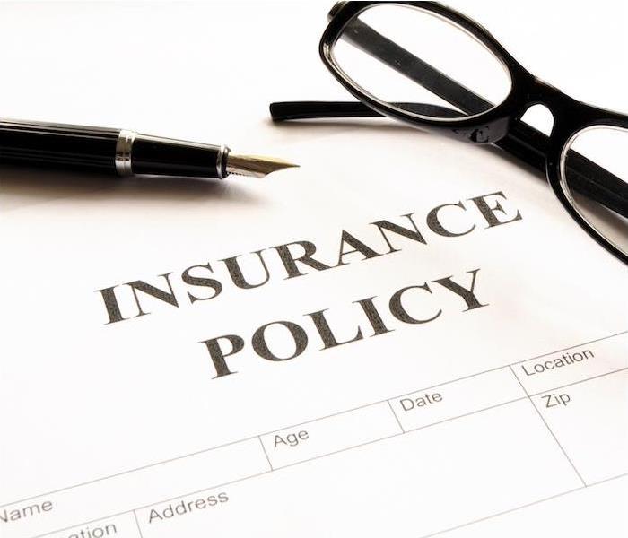 black glasses and pen sitting on top of white insurance policy